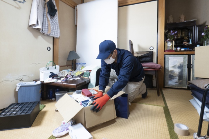 遺品を整理する男性作業員